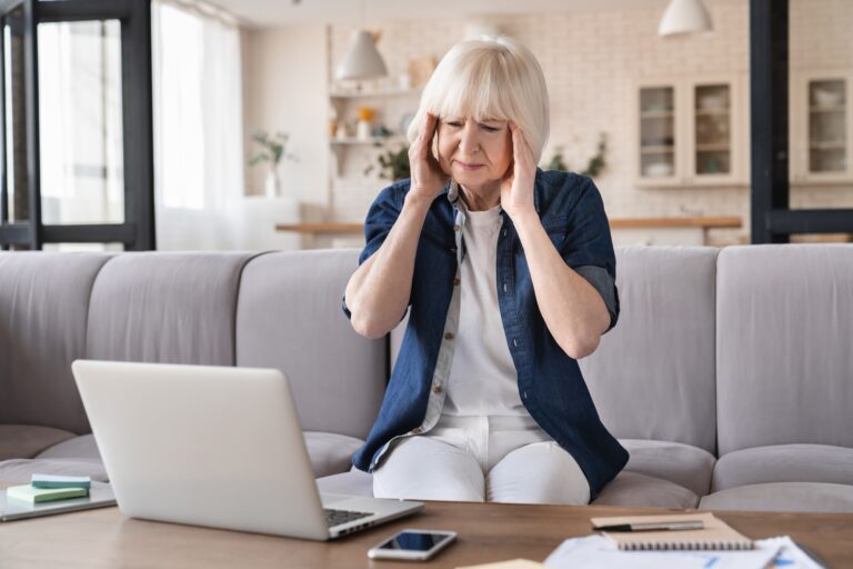 Exhausted tired depressed stressed old aged elderly business woman suffering from headache